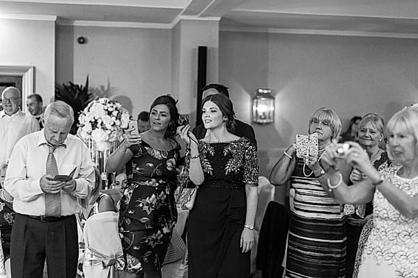 guests taking photos during first dance 