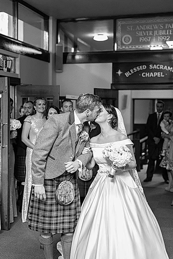 bride and groom kissing just outside church after wedding ceremony in glasgow