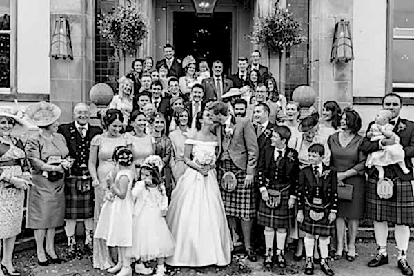 family photo with newlyweds kissing
