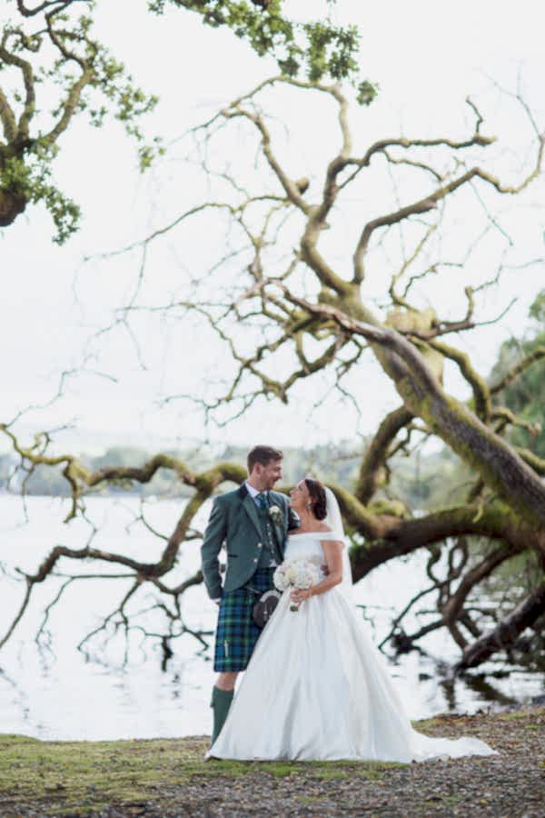 wedding photographer glasgow loch lomond fallen tree with bride and groom