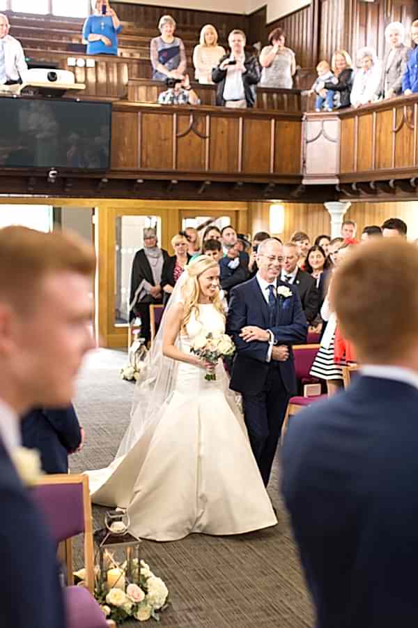 bride walking down the aisle in the hamilton church scotland 