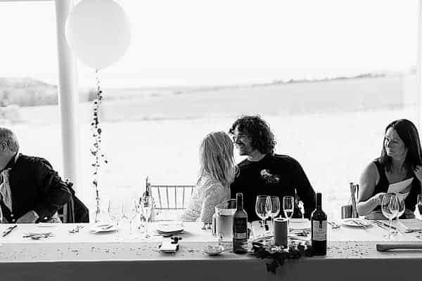 bride and groom kissing during speeches