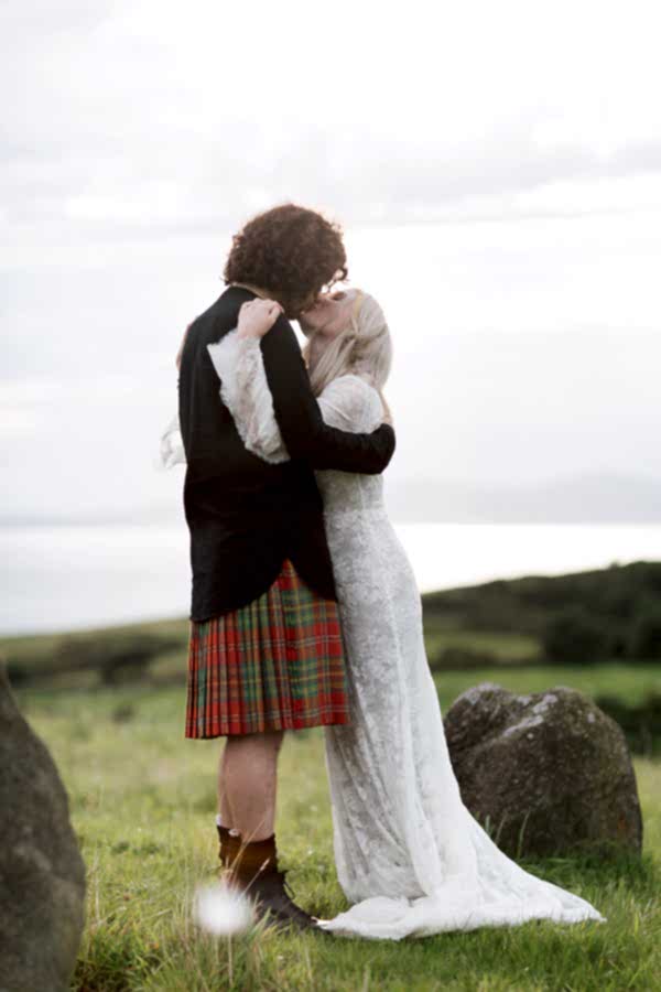 bride and groom kissing on a scottish hill