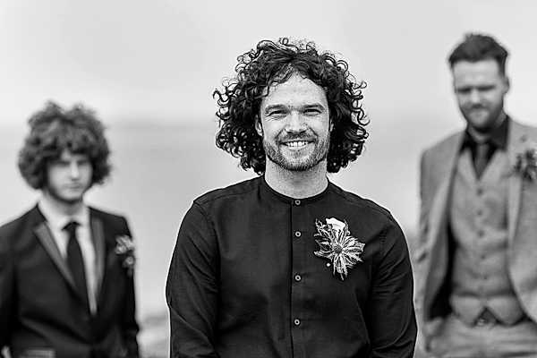groom in black shirt looking cool scottish style