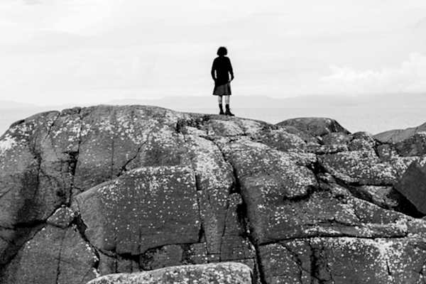 groom in a kilt on a rock looking at the view