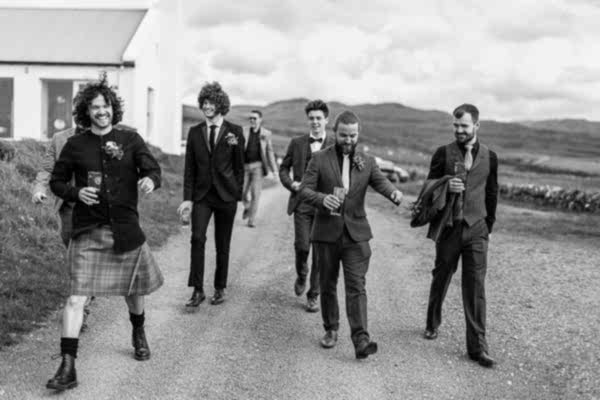 groom and groomsmen laughing and drinking beer