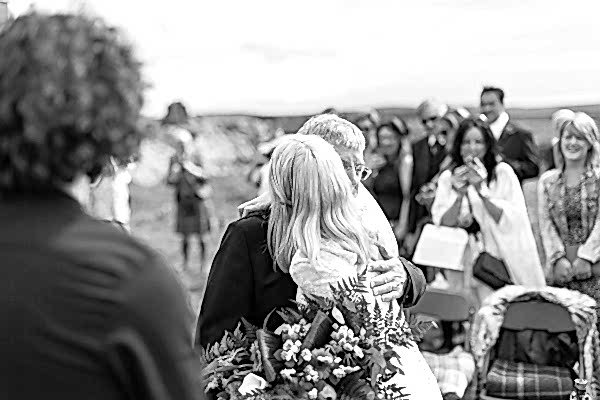 bride huging his dad at the altar outdoors