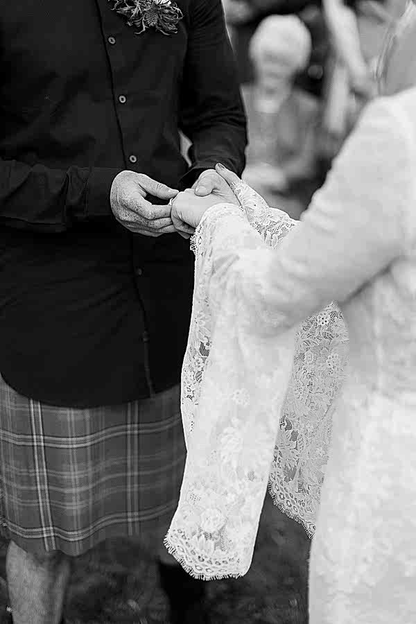 groom putting ring on brides finger