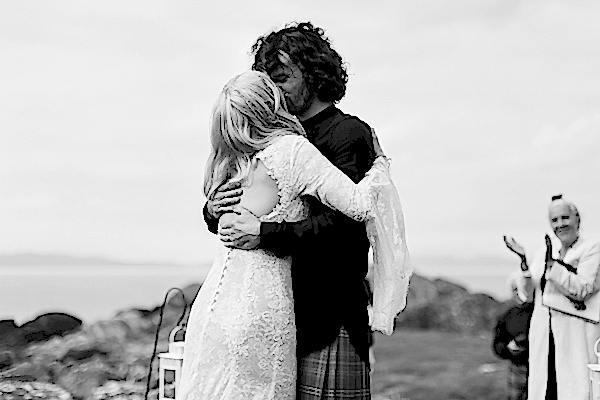bride and groom kissing during outdoors ceremony