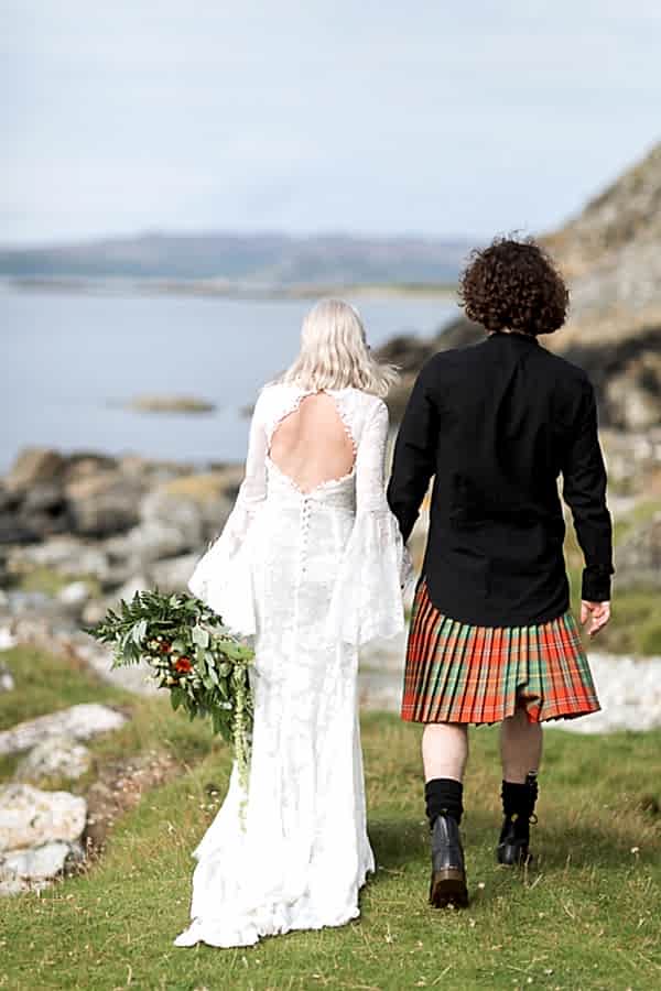 newlyweds walking toward beach view from back