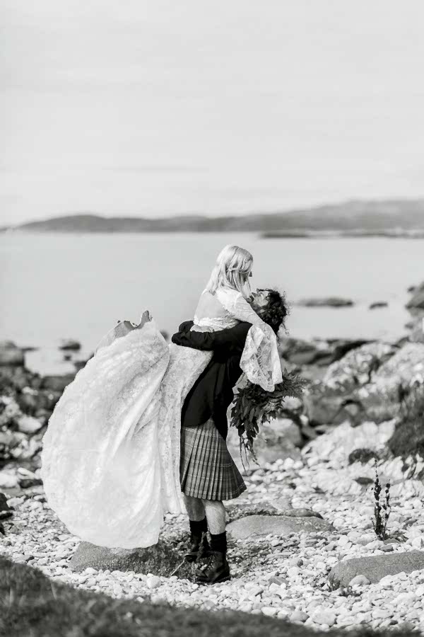 wedding photographers glasgow groom lifting bride on a beach