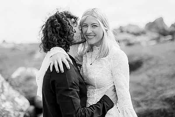 groom kissing bride on a cheek smiling