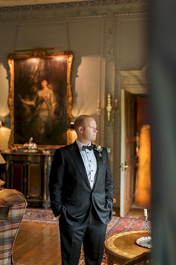 groom looking through the window at dundas castle near edinburgh