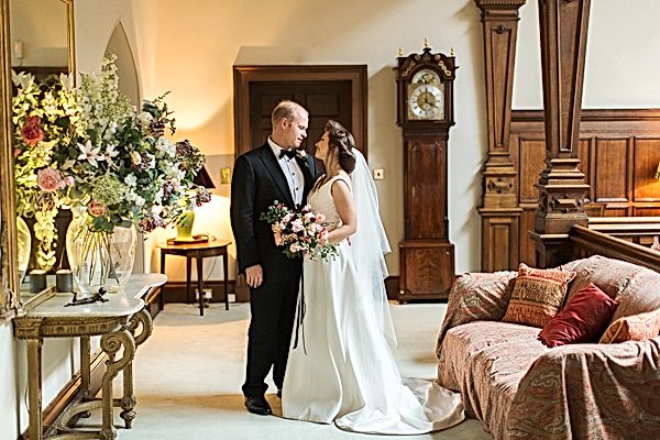 wedding couple holding each other in lovely interior of dundas castle