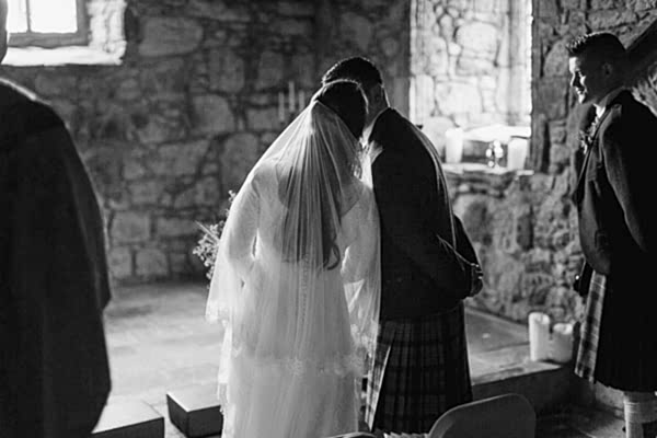 bride quickly kisses the groom at teh church ceremony