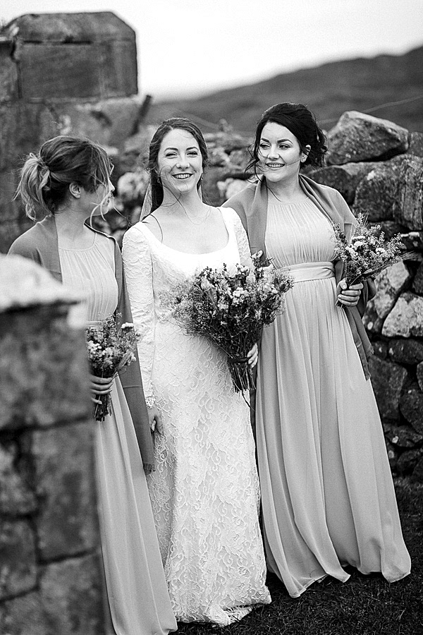 bride laughing with bridesmates just outside the church in scotland