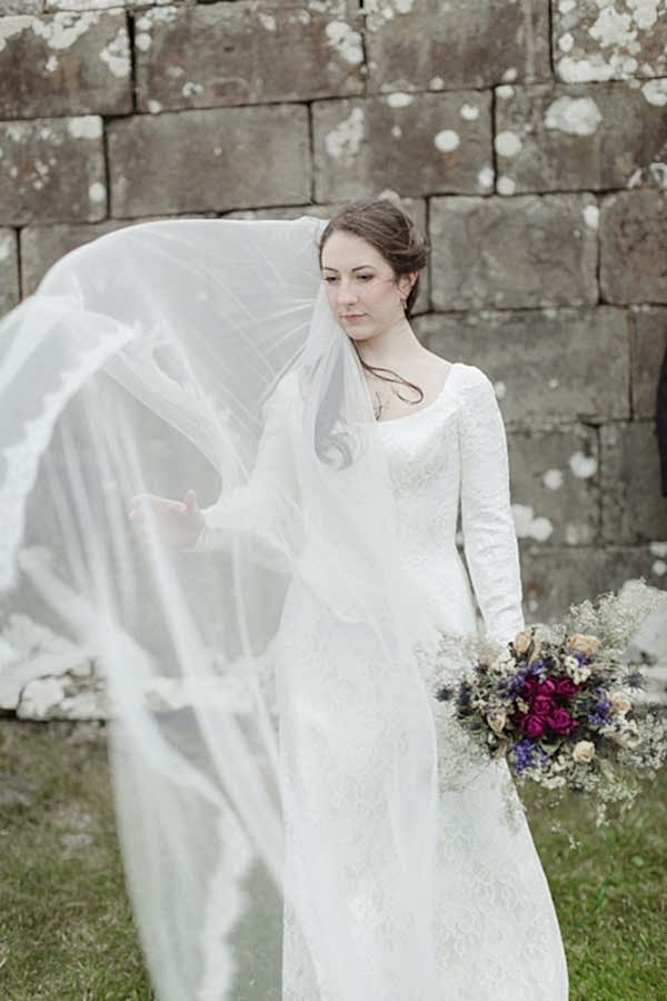 bride trying to catch her veil on the wind