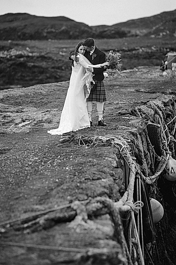newlyweds embraced standing on an old pier
