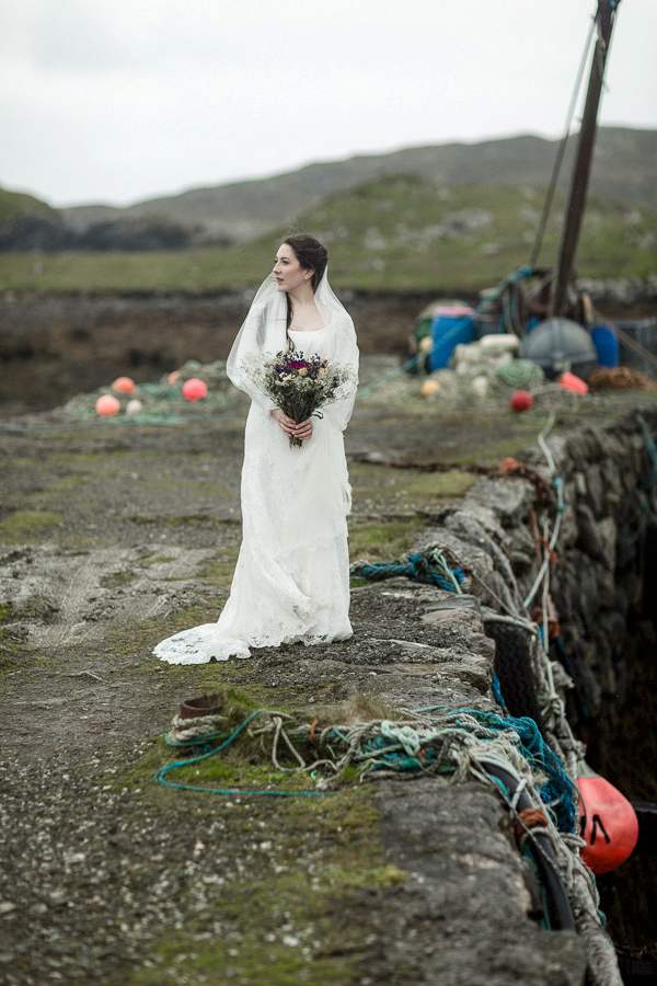 bride standing alone on a scottish pier