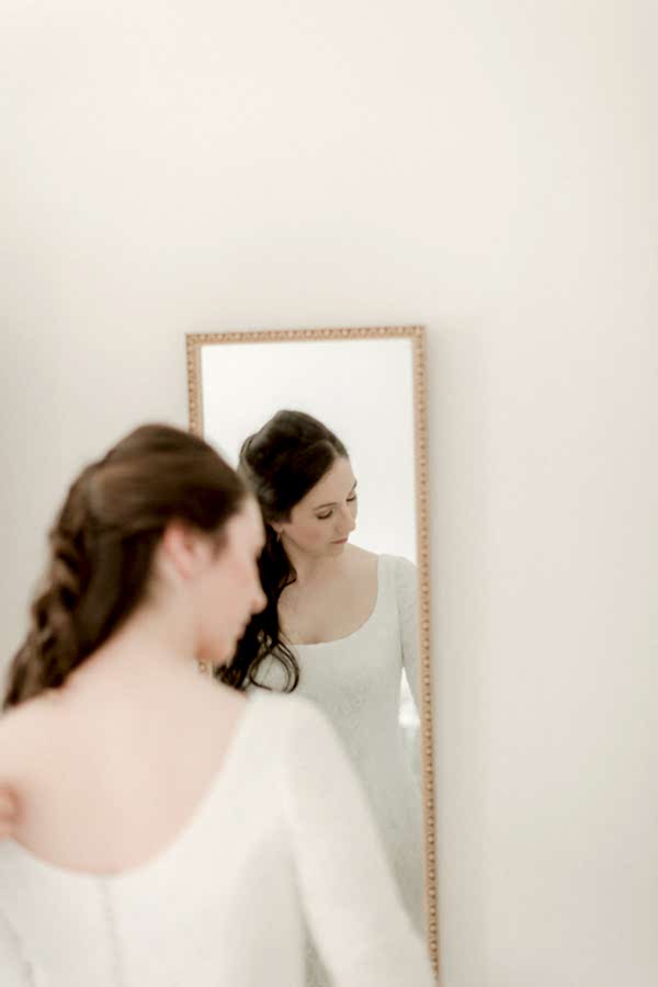 bride fixing her hair during preparations at home