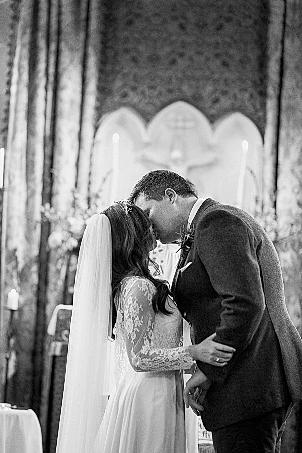 a couple kissing in the chapel at cromlix house 