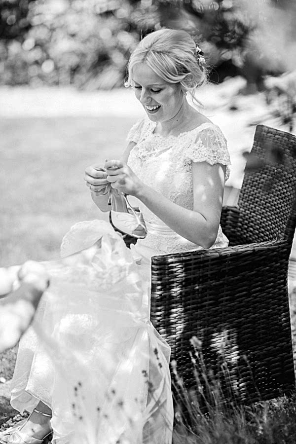 bride in her garden puttign her shoes on 
