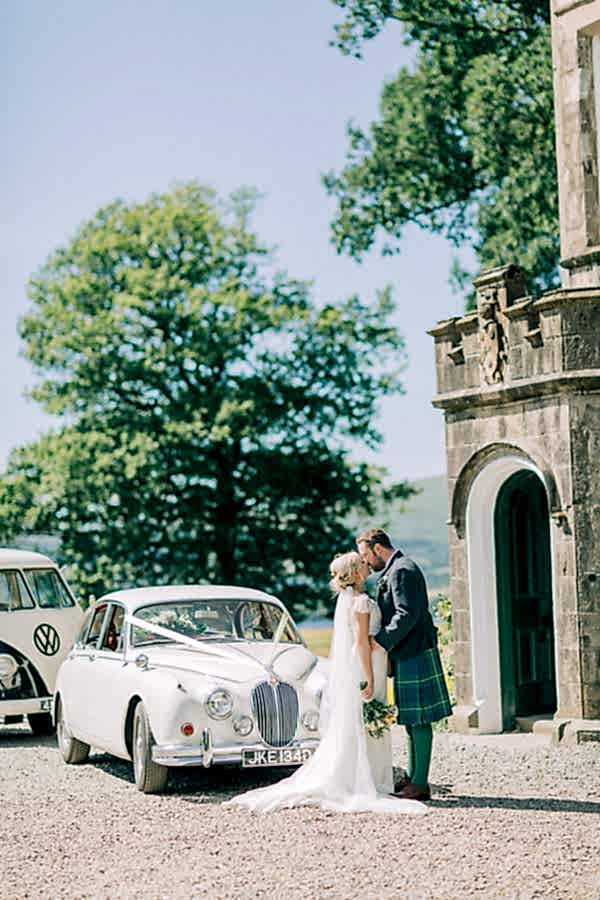 couple kissing outside of a castle loch lomond 
