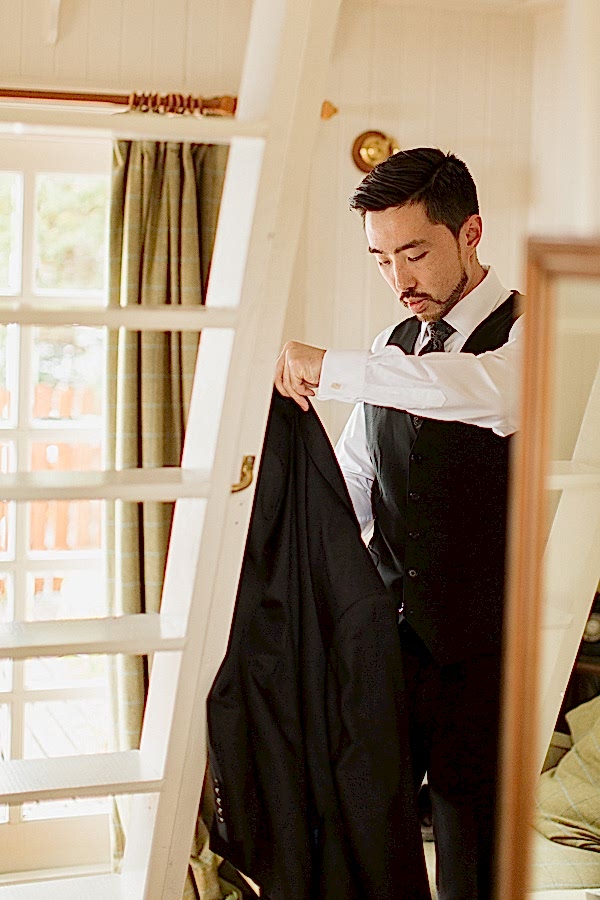 fotogenic of scotland groom putting his jacket onfor wedding
