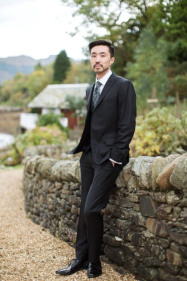 groom in full suit in garden 