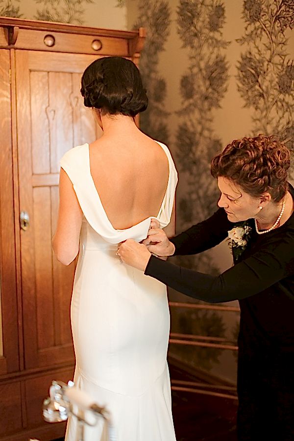 mother of the bride zipping the wedding dress