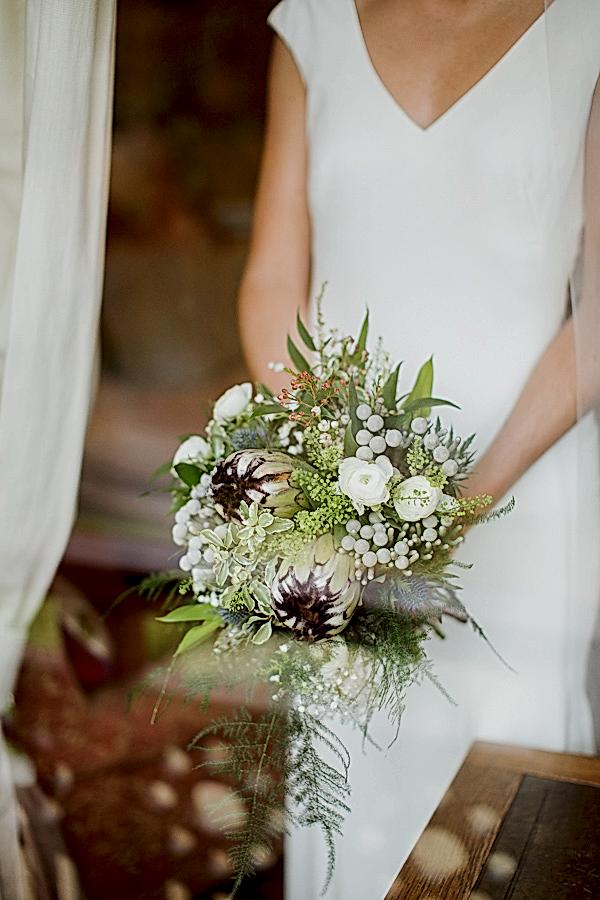 bride holding flowers view through the window