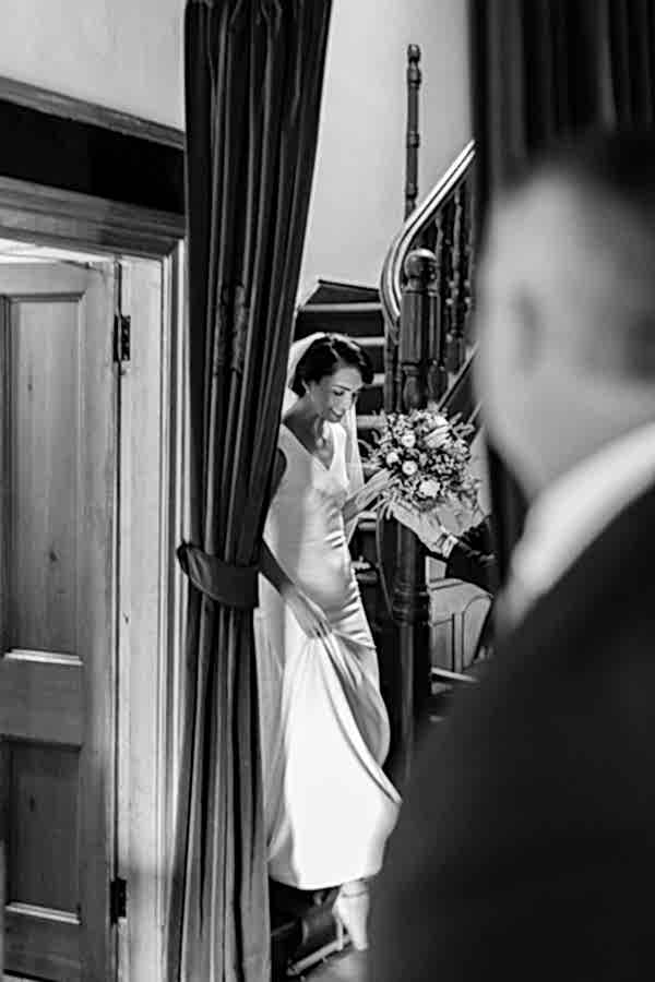 bride walking down stairs while father is looking