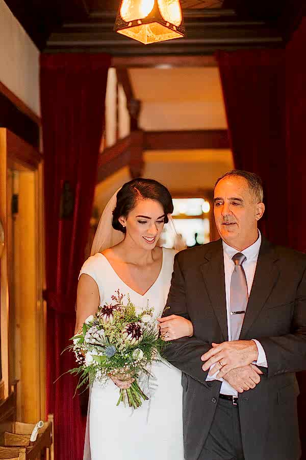father of the bride is walking her to the ceremony at the tree house at the lodge on loch goil