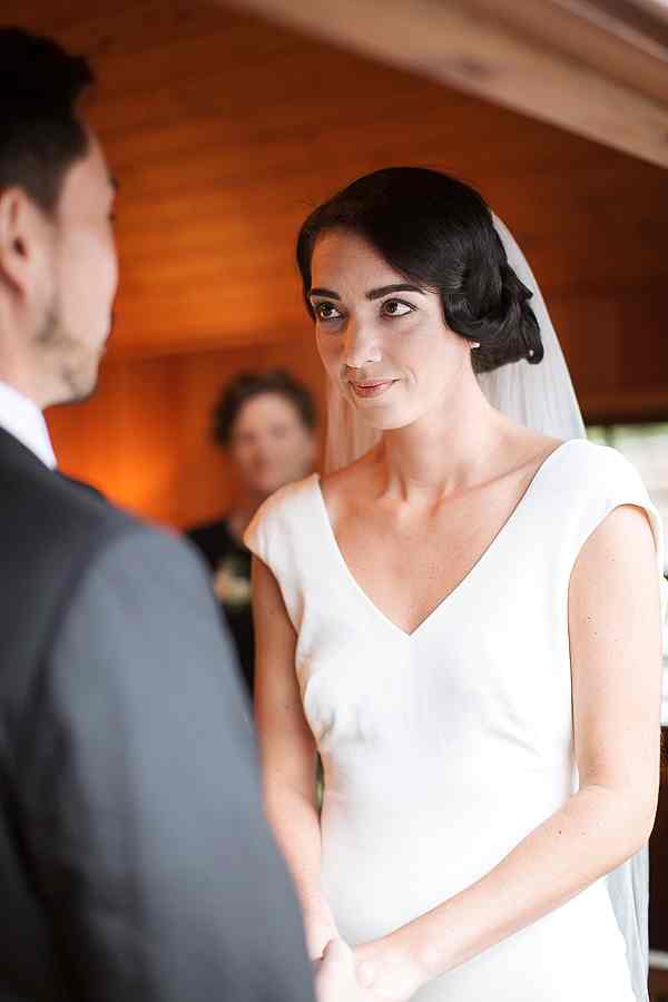 bride looking at groom during ceremony at tree house