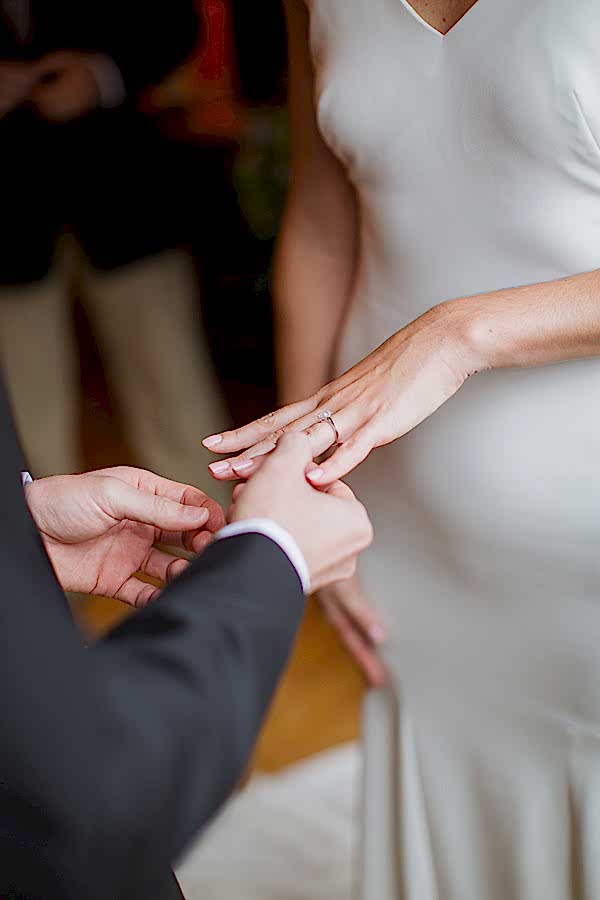 groom is putting ring on 
