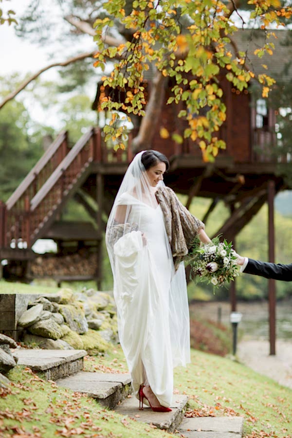 bride beeing held by her hand by groom in the ground of the lodge on loch goil