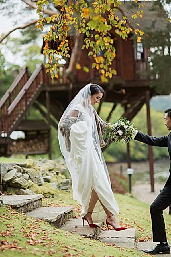 bride walking down with help of groom at the lodge gardens