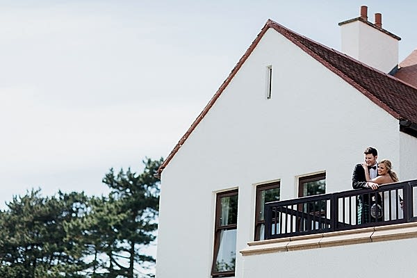 bride and groom on the balcony of lochgreen hotel