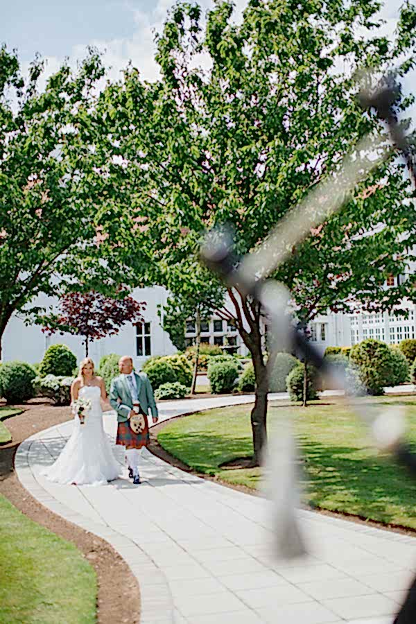 bride walking down in teh garden for ceremony at lochgreen hotel