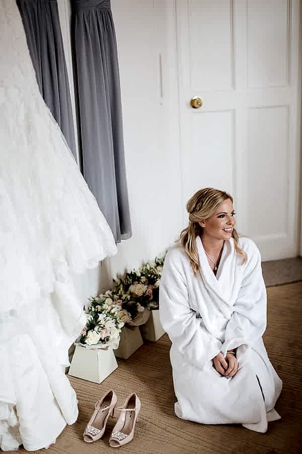 bride sitting next to her dress and flowers at lochgreen wedding preparations