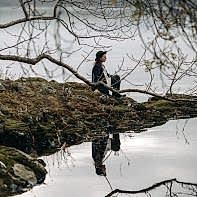 girl sitting on the edge of lake with reflexion scotland
