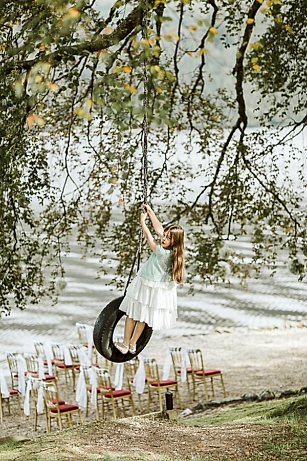 grils swinging on a tire at the lodge on loch goil in scotland