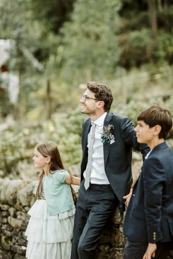 groom with kids looking at the bride