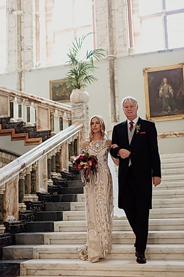 dad and bride walking down teh stairs for ceremony in scotland