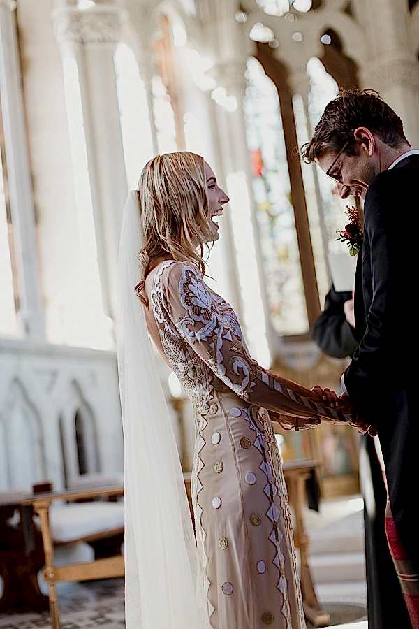 lauging and holdign hands during wedding ceremony