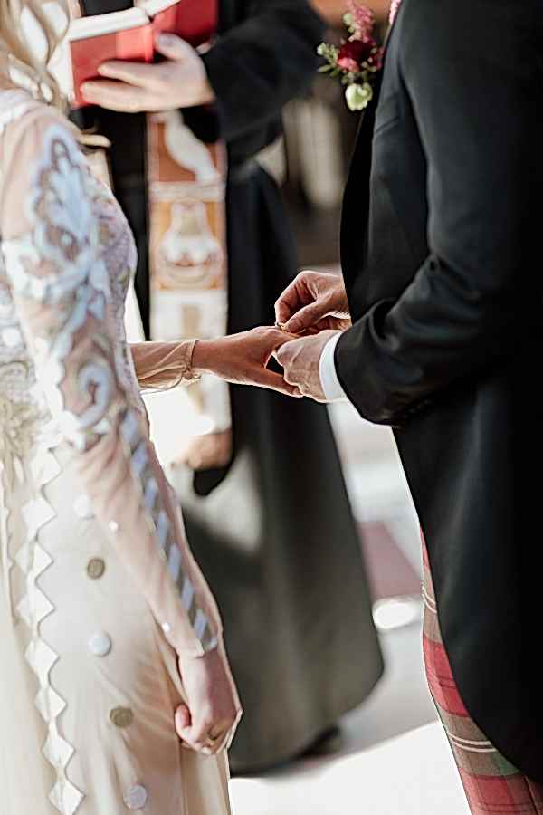 groom putting ring on brides finger scotland