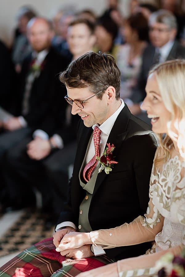 groom and bride smiling during church ceremony