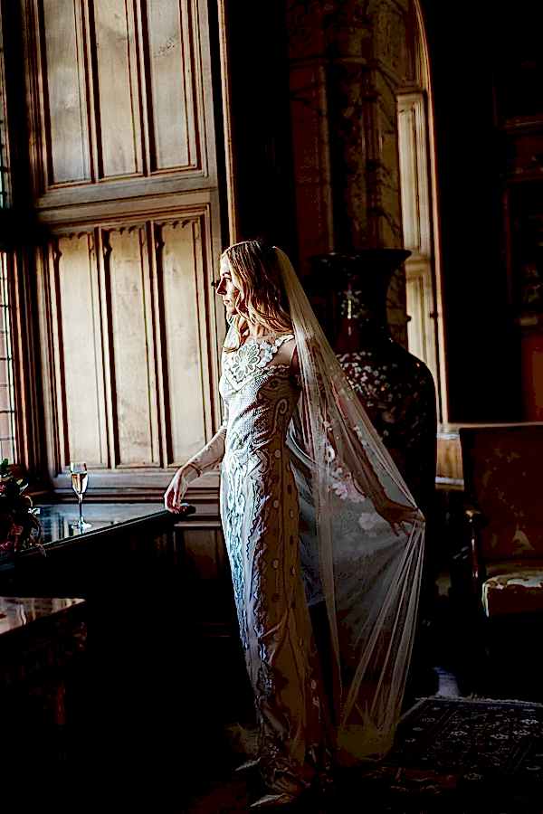 bride spreading her veil looking through the window