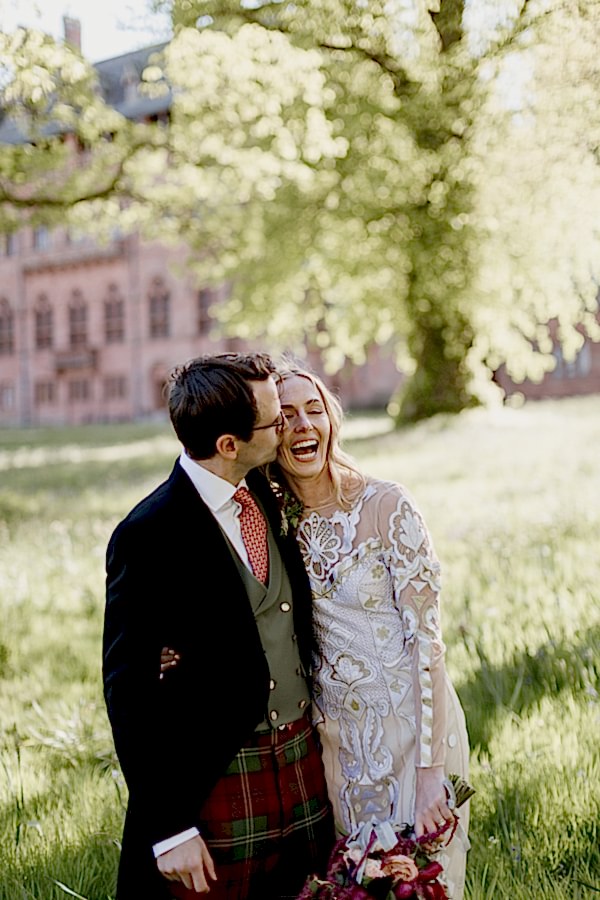 bride and groom kissing and laughing in the garden of mount stuart