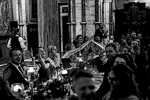guests cheering during wedding speeches